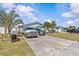 Exterior of a light blue home with a spacious driveway and tropical landscaping at 13815 Plumosa Ave, Hudson, FL 34667