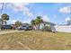 Light blue home with spacious front lawn, driveway parking, and tropical landscaping at 13815 Plumosa Ave, Hudson, FL 34667