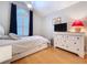 Bright bedroom with wood floors, large window and black out curtains, dresser and fan at 16022 Westerham Dr, Tampa, FL 33647
