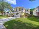 Beautiful yellow two-story home with a lush green lawn and mature trees in a serene setting at 16022 Westerham Dr, Tampa, FL 33647