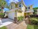 Inviting yellow home with brick accents, a well-maintained lawn, and a brick walkway to the entrance at 16022 Westerham Dr, Tampa, FL 33647