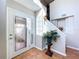 Bright foyer with tile flooring, a glass-paneled door, and a staircase adorned with decorative accents at 16022 Westerham Dr, Tampa, FL 33647