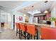 Granite countertop breakfast bar in the kitchen has orange high-top chairs at 16022 Westerham Dr, Tampa, FL 33647