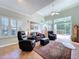 Bright living room with tile flooring, comfortable leather furniture, and expansive windows leading to the backyard at 16022 Westerham Dr, Tampa, FL 33647