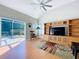 Open living room with a ceiling fan, hardwood floors, media center and sliding doors to the patio at 16022 Westerham Dr, Tampa, FL 33647
