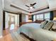 Comfortable main bedroom with tray ceilings, a ceiling fan, and hardwood floors at 16022 Westerham Dr, Tampa, FL 33647