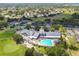 Stunning aerial view of the clubhouse featuring a pool, tennis courts, and golf course, nestled in a vibrant community at 18109 Tiverton Ct, Hudson, FL 34667