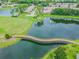 Breathtaking aerial view of the community featuring a bridge over a pond, golf course, and lush landscaping at 18109 Tiverton Ct, Hudson, FL 34667
