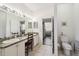 Bright bathroom with double vanity, neutral tile flooring, and separate toilet room at 18109 Tiverton Ct, Hudson, FL 34667