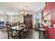 Dining room featuring wood-look floors, chandelier, china cabinet, and kitchen bar with stools at 18109 Tiverton Ct, Hudson, FL 34667
