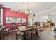 Dining room area with a red accent wall, a view into the kitchen, and wood-look floors at 18109 Tiverton Ct, Hudson, FL 34667