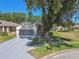 Lovely home with a screened two-car garage, landscaped front yard, and a concrete driveway at 18109 Tiverton Ct, Hudson, FL 34667