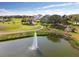 Scenic aerial shot of the golf course and community clubhouse with a lake and fountain feature at 18109 Tiverton Ct, Hudson, FL 34667