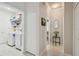 Bright hallway leading to a laundry room, featuring tile flooring, neutral paint, and ample closet space at 18109 Tiverton Ct, Hudson, FL 34667