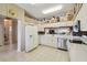 A bright kitchen featuring white cabinetry, stainless steel appliances, tile backsplash, and open layout at 18109 Tiverton Ct, Hudson, FL 34667