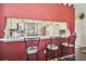 Kitchen bar featuring three stools, a counter looking into the kitchen, and a red accent wall at 18109 Tiverton Ct, Hudson, FL 34667