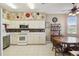 Bright kitchen with white cabinets, stainless steel appliances, tile backsplash, and tiled flooring at 18109 Tiverton Ct, Hudson, FL 34667