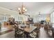 Open-concept living and dining area with wood floors, chandelier, and a view of the lanai at 18109 Tiverton Ct, Hudson, FL 34667