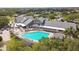 Overhead view of the large community pool and clubhouse, surrounded by mature trees and manicured landscaping at 18109 Tiverton Ct, Hudson, FL 34667