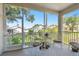 Screened porch with seating and views of the backyard at 18109 Tiverton Ct, Hudson, FL 34667
