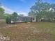 Expansive backyard featuring mature trees, a screened-in pool area, and well-maintained green spaces at 18232 Monteverde Dr, Spring Hill, FL 34610