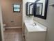 Bathroom featuring tile flooring, a large vanity with modern fixtures, and updated lighting at 18232 Monteverde Dr, Spring Hill, FL 34610