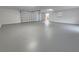 Spacious garage featuring a large gray epoxy floor, windows and an automatic garage door at 18232 Monteverde Dr, Spring Hill, FL 34610