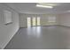 Spacious garage featuring a large gray epoxy floor, windows and double glass doors at 18232 Monteverde Dr, Spring Hill, FL 34610