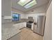 Well-lit kitchen with white cabinetry, granite countertops, and stainless steel appliances at 18232 Monteverde Dr, Spring Hill, FL 34610