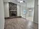 Spacious living room showcasing a brick fireplace, wood floors, and ample natural light at 18232 Monteverde Dr, Spring Hill, FL 34610