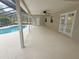 Covered patio features a ceiling fan, double doors, and a serene view of the sparkling pool area at 18232 Monteverde Dr, Spring Hill, FL 34610