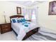 Bedroom with a bed, two side tables, ceiling fan and tile floor at 22106 Garmisch Way, Brooksville, FL 34601