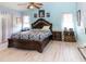Primary bedroom with a dark wood frame bed, ceiling fan, and light blue walls at 22106 Garmisch Way, Brooksville, FL 34601
