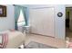 Cozy bedroom features closet, side table, neutral color palette, and tile flooring at 22106 Garmisch Way, Brooksville, FL 34601
