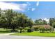 Home exterior showcasing a mature tree, sprawling lawn, and a well-maintained landscape at 22106 Garmisch Way, Brooksville, FL 34601