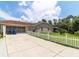 Wide driveway leading to an attached two-car garage with a charming white picket fence outlining the property at 22106 Garmisch Way, Brooksville, FL 34601