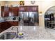 Kitchen with double refrigerator, custom cabinets, granite countertop and decor on top of cabinets at 22106 Garmisch Way, Brooksville, FL 34601