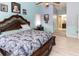 Bedroom with hardwood floors, ensuite bathroom, framed photos, and queen bed at 22106 Garmisch Way, Brooksville, FL 34601