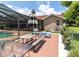 Outdoor dining set, lounge chairs, and a screened-in pool in the backyard at 22106 Garmisch Way, Brooksville, FL 34601