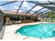 Backyard view of pool and brick patio with outdoor dining and entertainment area at 22106 Garmisch Way, Brooksville, FL 34601