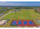 An aerial view of a vibrant park with tennis courts, playing fields, and walking paths at 3032 Jacob Crossing Ln, Holiday, FL 34691
