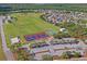Aerial view of expansive park showcasing tennis courts, baseball field, and vast green spaces at 3032 Jacob Crossing Ln, Holiday, FL 34691