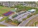 An aerial view showcasing the park's tennis courts, clubhouse, and parking lot in a green setting at 3032 Jacob Crossing Ln, Holiday, FL 34691