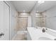Well-lit bathroom featuring double sinks, shower with tile surround, and neutral color palette at 3032 Jacob Crossing Ln, Holiday, FL 34691
