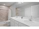 Bathroom featuring dual sinks, large mirror, shower with tile surround, and storage at 3032 Jacob Crossing Ln, Holiday, FL 34691