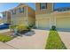 Charming townhome featuring attached garage, manicured landscaping, and light yellow painted exterior at 3032 Jacob Crossing Ln, Holiday, FL 34691