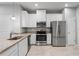 Modern kitchen featuring stainless steel appliances, granite countertops, and ample cabinet space at 3032 Jacob Crossing Ln, Holiday, FL 34691