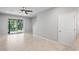 Open-concept living room with tile flooring, ceiling fan, and sliding glass doors to the lanai at 3032 Jacob Crossing Ln, Holiday, FL 34691