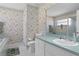 A bathroom with green floral wallpaper, a large mirror, a bathtub, and a toilet at 3345 Carmen Ave, Spring Hill, FL 34609