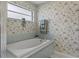 This bathroom features floral wallpaper, a bathtub, and a frosted window at 3345 Carmen Ave, Spring Hill, FL 34609